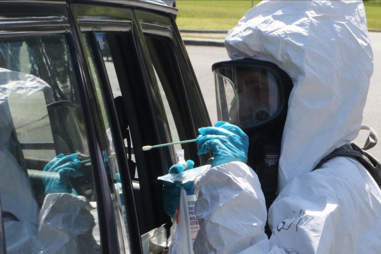 National Guard soldiers and airmen assist with a drive-thru COVID-19 testing site.