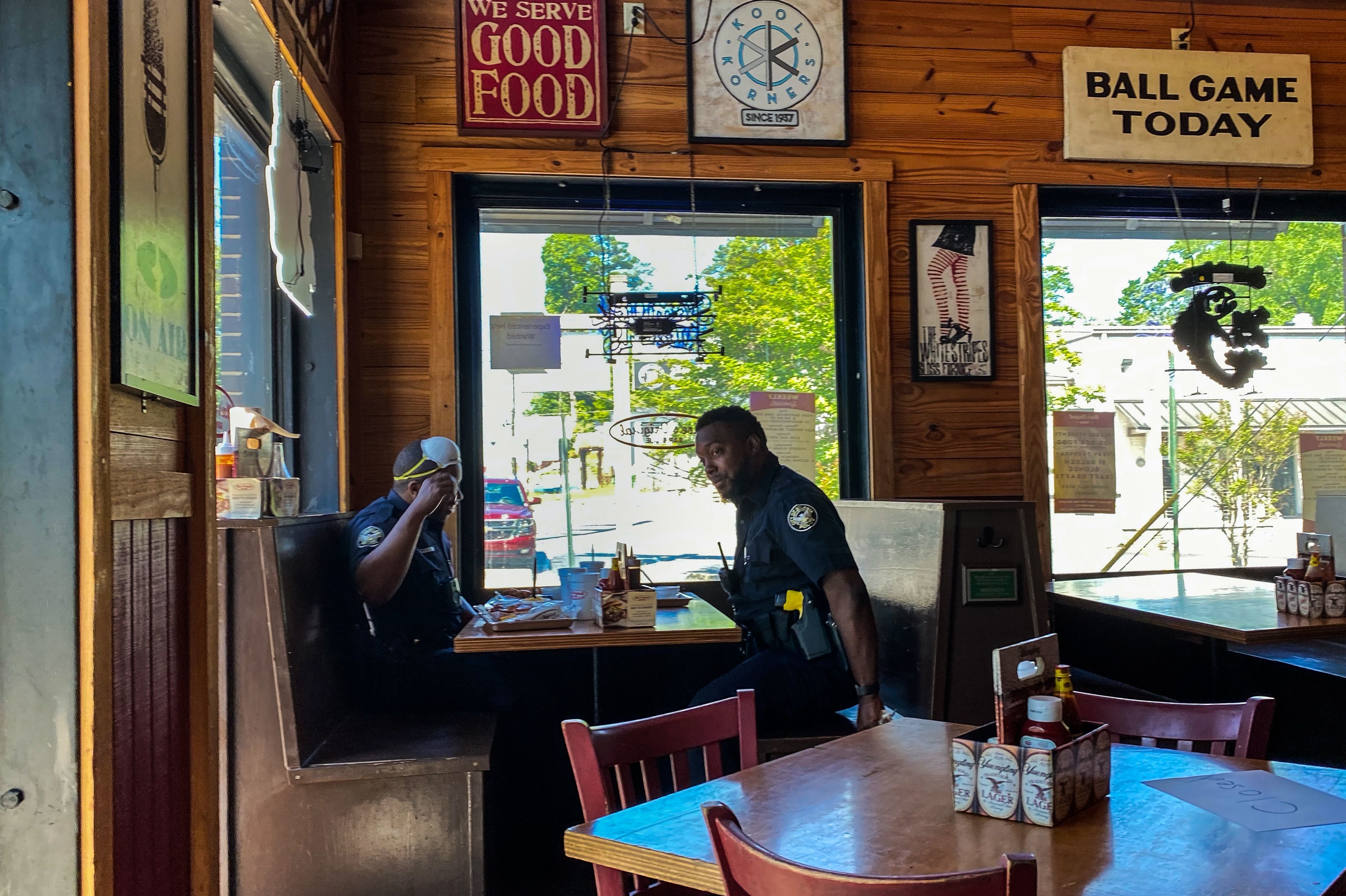 Two police officers get something to eat at Moe's Original BBQ