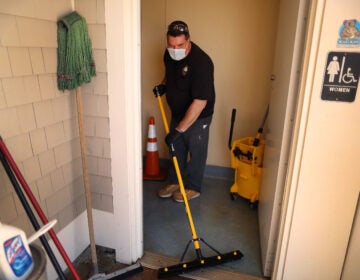 Town worker Steve Crowley washes and disinfects the public restroom at Mayflower Beach, in Dennis, Mass., last week. As stay-at-home restrictions are lifting, many people are concerned about using public restrooms. (John Tlumacki/The Boston Globe via Getty Images)
