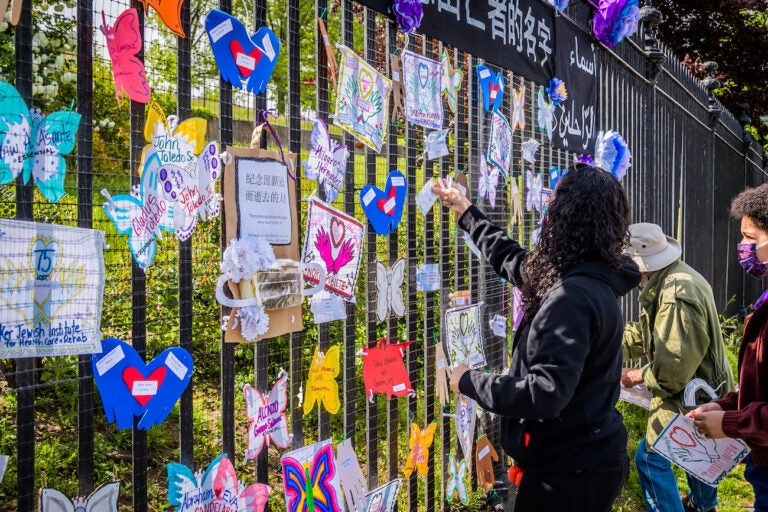 A volunteer artist sets up a memorial in Brooklyn on May 20. Artists and volunteer organizers across New York City put up physical memorials throughout the five boroughs in connection with Naming the Lost to honor the lives lost to COVID-19. (Erik McGregor/LightRocket via Getty Images)