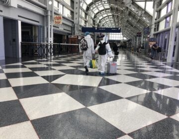 A couple dressed in protective gear walks through Chicago's O'Hare International Airport