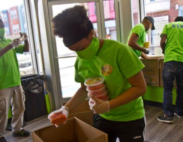 Kierah Rigney, 14, packs strawberry water to to go essential workers at the University of Pennsylvania’s hospital in Philadelphia. (Kimberly Paynter/WHYY)