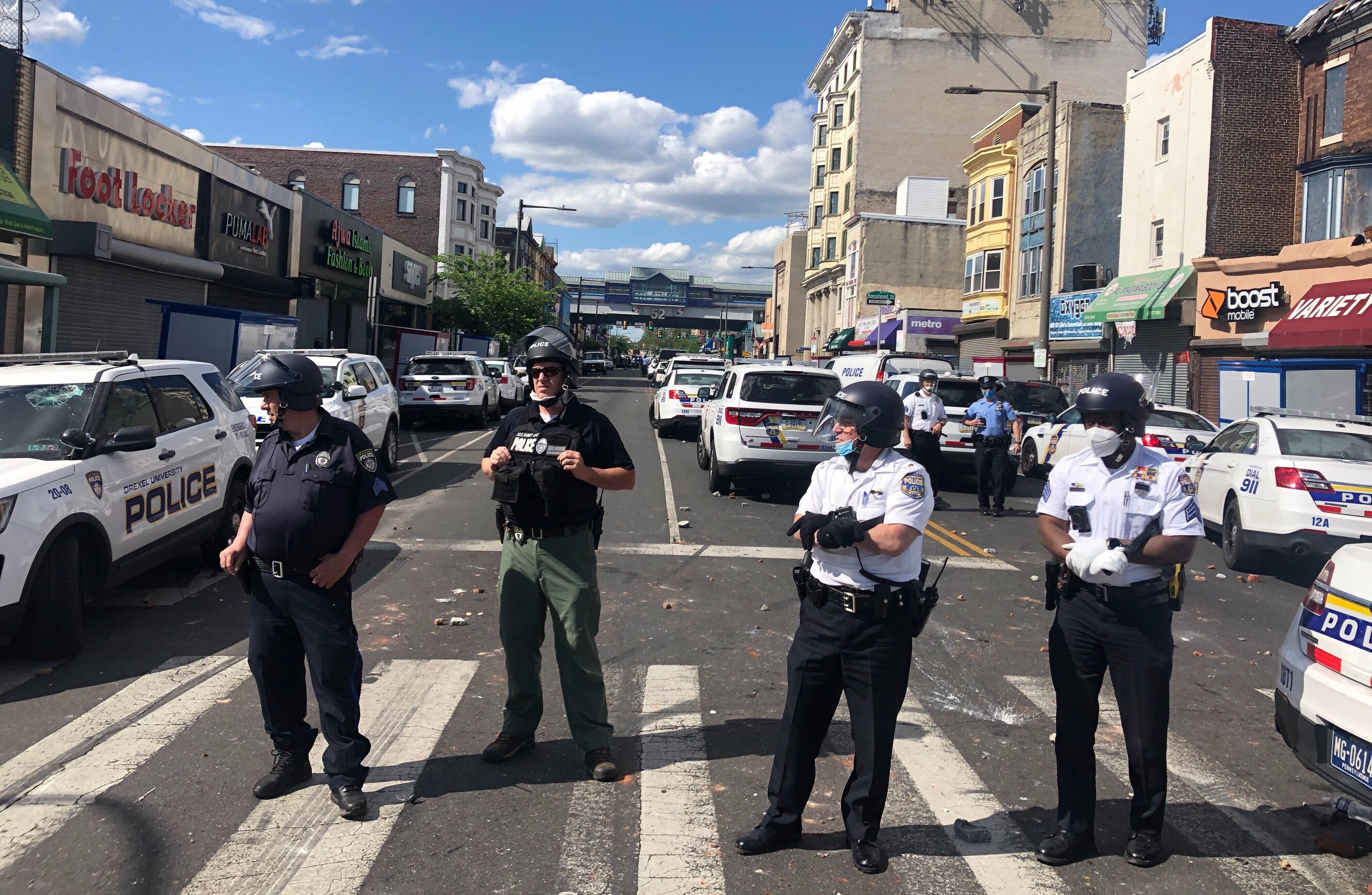 Officers stand at 52nd and Chestnut streets as protests continue across the city.