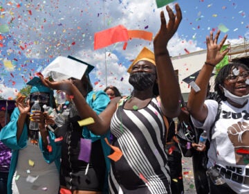 At Farnham Park on June 26, Camden High graduate Zanabria Harris, 18, stands in a sea of confetti at the end of the parade.  (Photo by April Saul for WHYY)