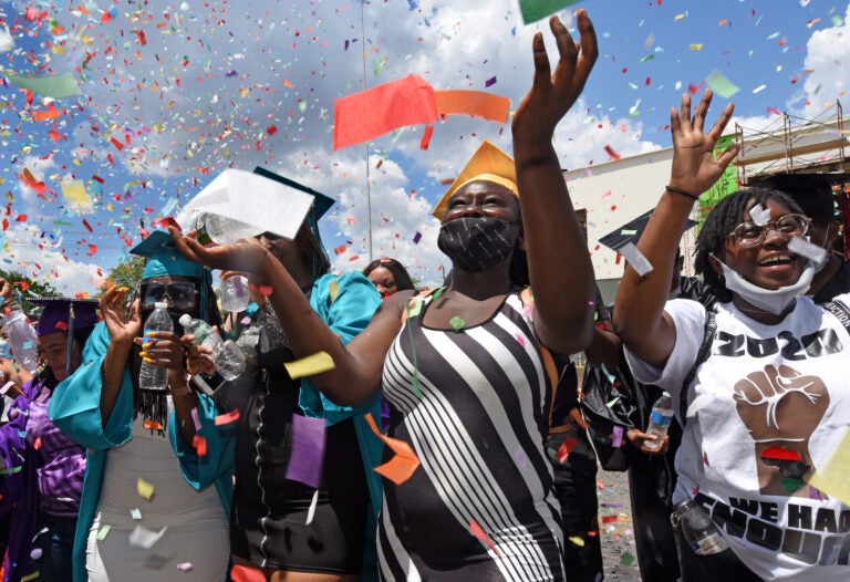 At Farnham Park on June 26, Camden High graduate Zanabria Harris, 18, stands in a sea of confetti at the end of the parade.  (Photo by April Saul for WHYY)