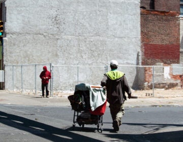 A person walks with their belongings on Kensington Avenue on May 7, 2020. (Erin Blewett / Kensington Voice)