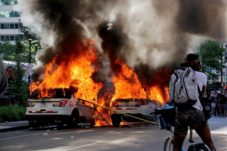 Police cars burn in front of City Hall