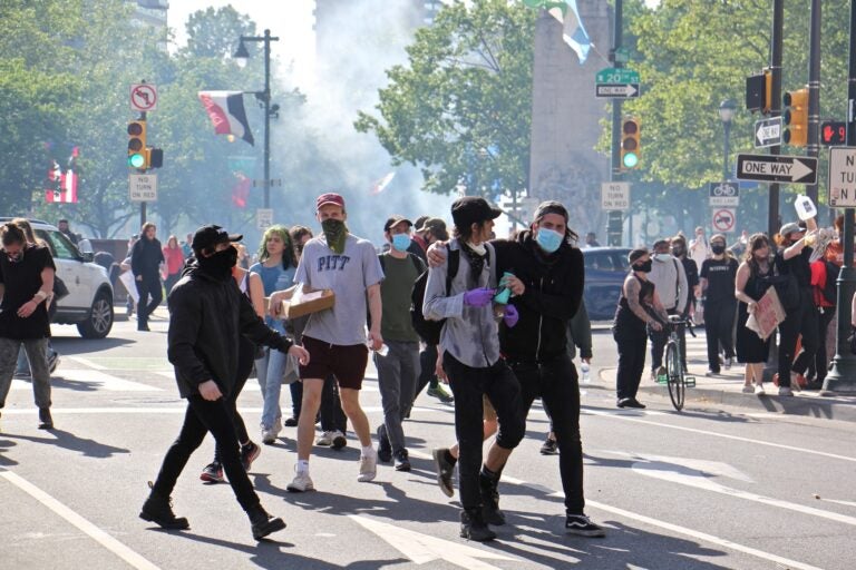 Protesters flee a cloud of tear gas