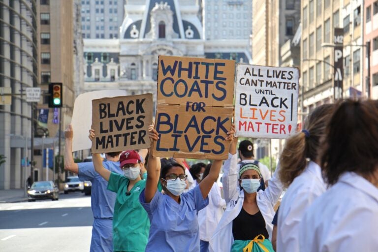 Protesters in scrubs and lab coats