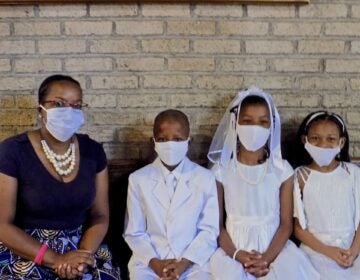 Jennifer Ballard (left) accompanies her children (from lert) Allan and Allyson Ballard, and their friend Joselyn Turner, as they get ready for their First Holy Communion. (Ximena Conde/WHYY News)