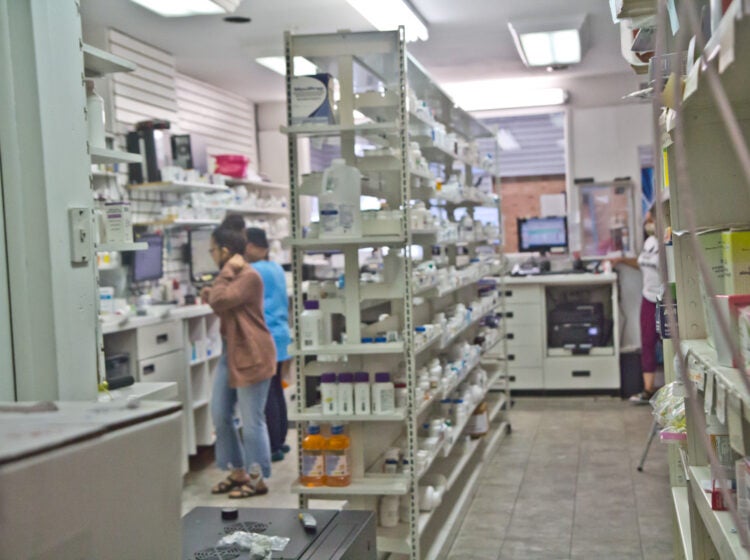 Workers inside a small pharmacy filling scripts