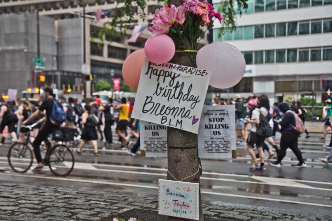 Protesters march by a tree decorated in honor of Breonna Taylor, who would have been 27 today, in Center City Philadelphia. (Kimberly Paynter/WHYY)