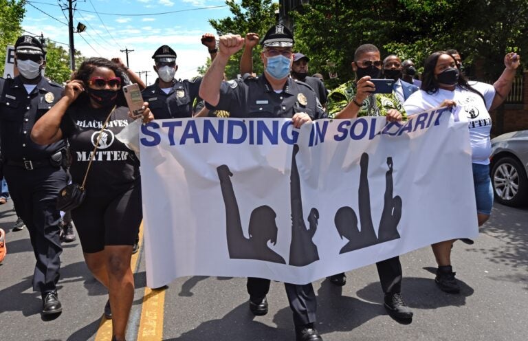 Camden County Metro Police Chief Joe Wysocki raises a fist while marching with Camden residents and activists on May 30, 2020 to protest the killing of George Floyd in Minneapolis. (Photo by April Saul via AP)