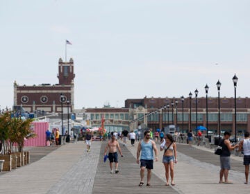 People walk along the boardwalk in Asbury Park, N.J., Wednesday, June 21, 2017. (AP Photo/Seth Wenig)