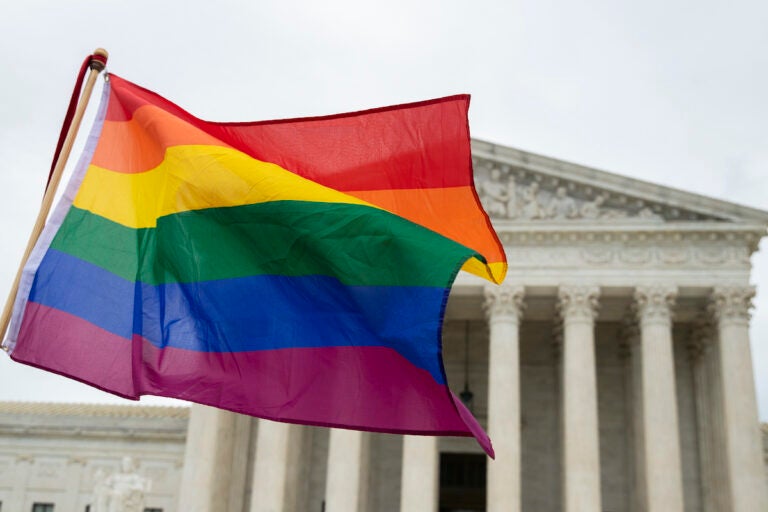 Supporters of the LGBT wave their flag in front of the U.S. Supreme Court, Tuesday, Oct. 8, 2019, in Washington. (AP Photo/Manuel Balce Ceneta)