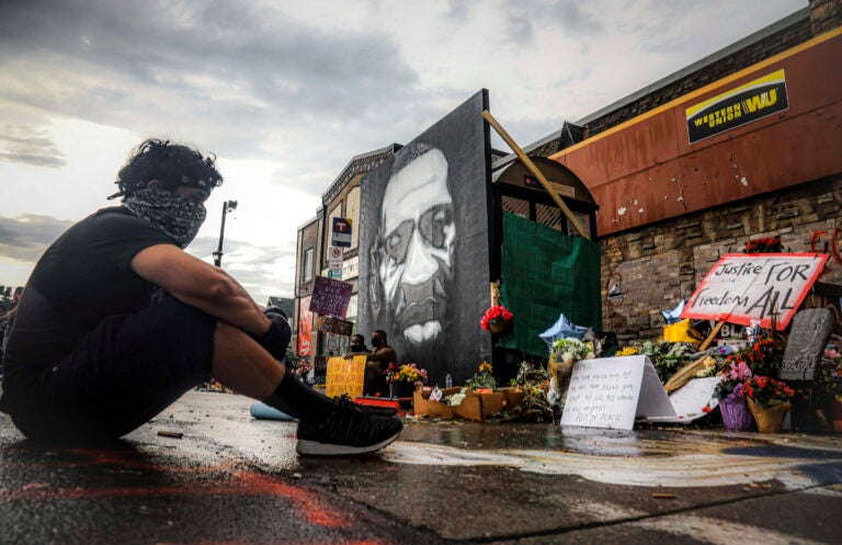 Trevor Rodriquez sits alone at the spot where Floyd died at the hands of police