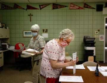 Guidance secretary Marge Berckmiller, left, and Sister Bridget Reilly, director of guidance, prepare student transcripts to send to other schools after the closure of Quigley Catholic High School in Baden, Pa., Monday, June 8, 2020. (AP Photo/ Jessie Wardarski)