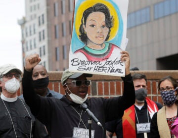 In this June 9, 2020, file photo, Kevin Peterson, center, founder and executive director of the New Democracy Coalition, displays a placard showing Breonna Taylor as he addresses a rally in Boston. (AP Photo/Steven Senne, File)