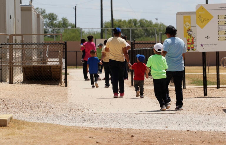 In this Aug. 23, 2019 file photo, immigrants seeking asylum hold hands as they leave a cafeteria at the ICE South Texas Family Residential Center in Dilley, Texas. (AP Photo/Eric Gay, File)