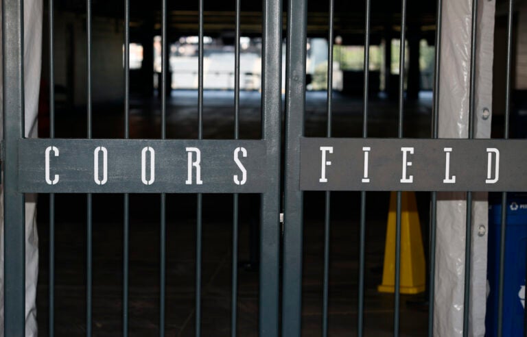 The main gate of Coors Field, home of the Major League Baseball team the Colorado Rockies, is locked early Tuesday, June 23, 2020, in Denver. (AP Photo/David Zalubowski)