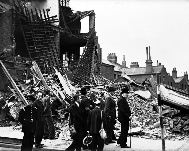 Britain's Prime Minister Winston Churchill, right, accompanied by officials, inspects the damage caused by German bombs in London's East End, Sept. 9, 1940, during the Blitz.  (AP Photo/British Official Photo)