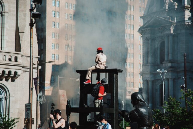 Protesters watch smoke from police vehicles rise. (Phobymo)