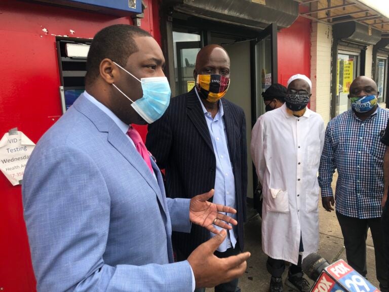 Councilmember Kenyatta Johnson spoke with workers and community members at Woodland Village Plaza in Southwest Philadelphia on Tuesday morning. (Meir Rinde for WHYY)