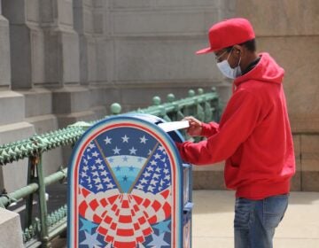 Odell Griffin places his mail-in ballot in a box outside City Hall.