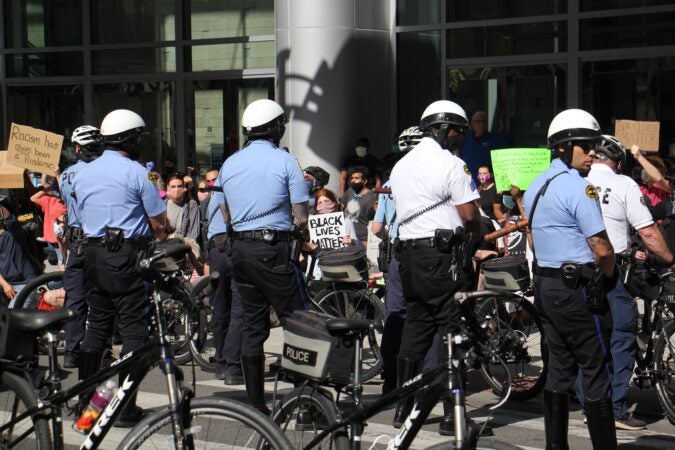 Protesters at the Pennsylvania Convention Center urge police to ‘take a knee in solidarity.’ (Emma Lee/WHYY)