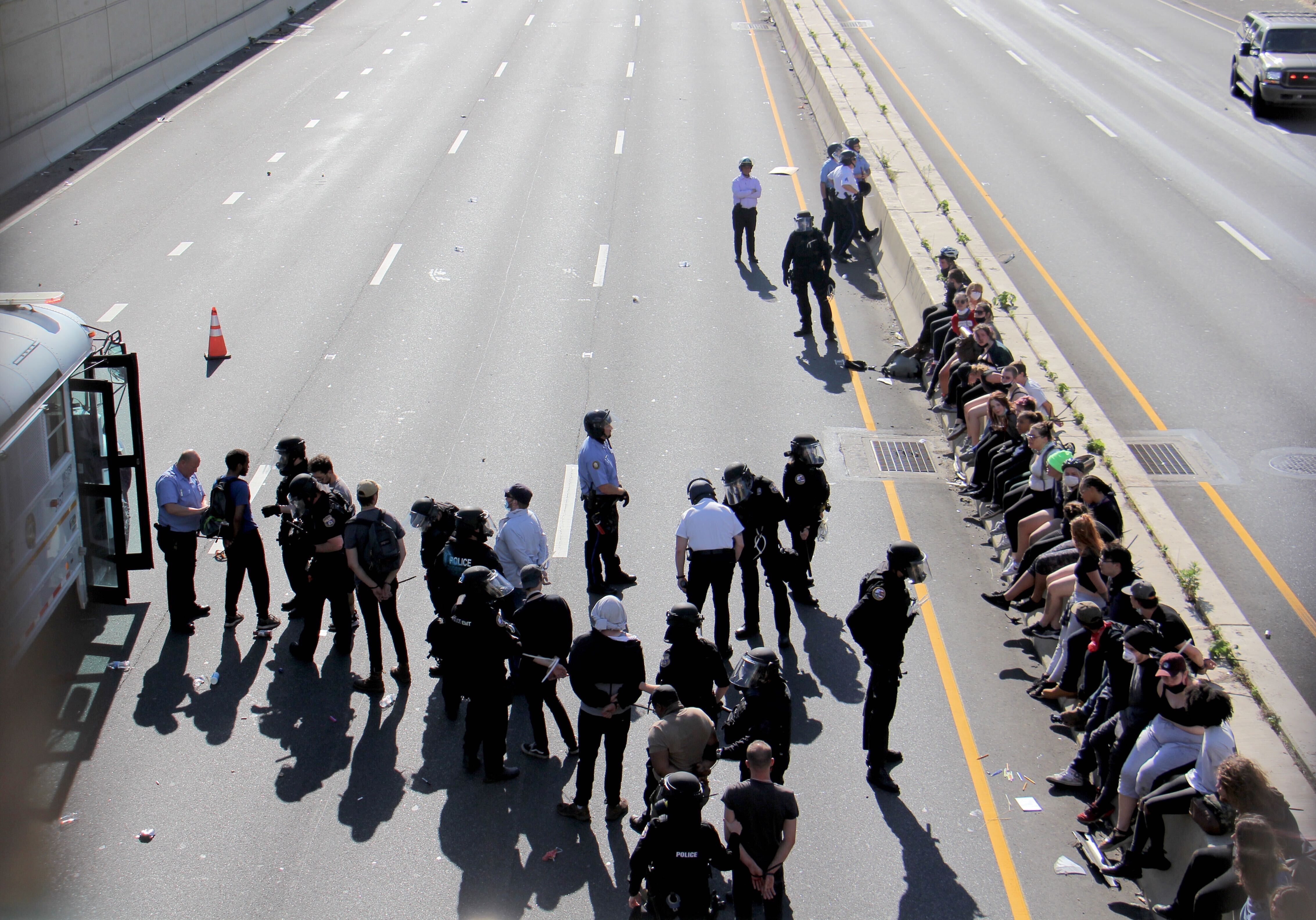 Police load arrested protesters into a Sheriff’s Office bus after closing Route 676 in both directions.