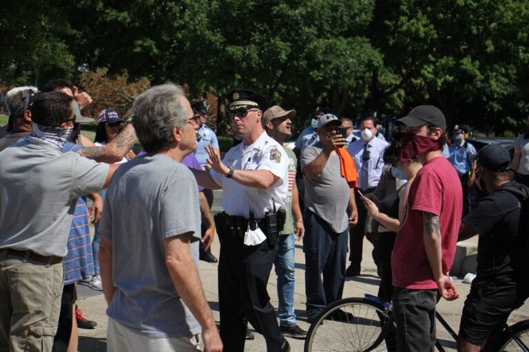 Capt. Michael O’Donnell steps between protesters as tensions rise near the statue of Christopher Columbus in Marconi Plaza. (Emma Lee/WHYY)