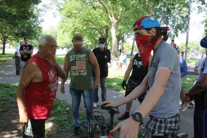 Statue defenders and an anti-Columbus protester argued at Marconi Plaza in mid-June. (Emma Lee/WHYY)