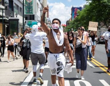 Chris Bowman holds up a fist demanding justice for Black people in the U.S. during a Juneteenth march in Philadelphia. (Kimberly Paynter/WHYY)