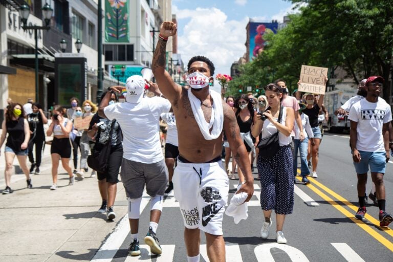 Chris Bowman holds up a fist demanding justice for Black people in the U.S. during a Juneteenth march in Philadelphia. (Kimberly Paynter/WHYY)