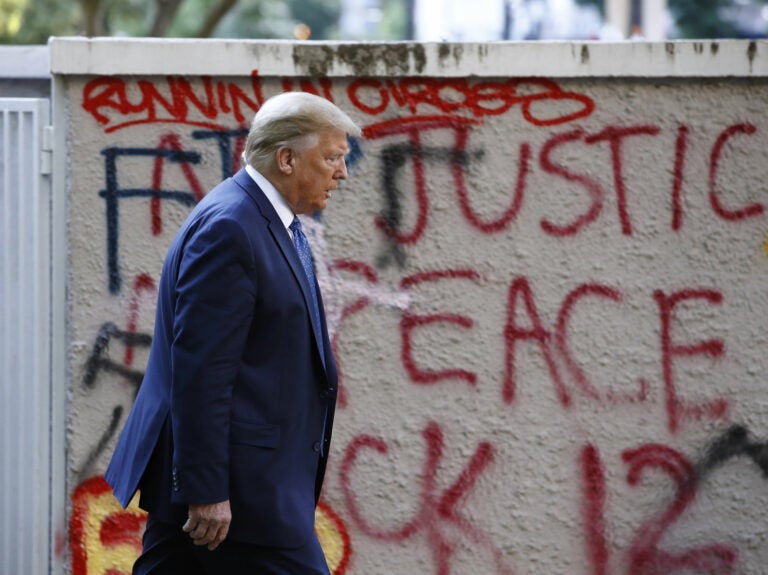 President Trump walks past protest graffiti in Lafayette Park