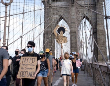 Protesters and activists walk across the Brooklyn Bridge Saturday in New York. Cities saw some of their biggest gatherings of the past two weeks on Saturday.