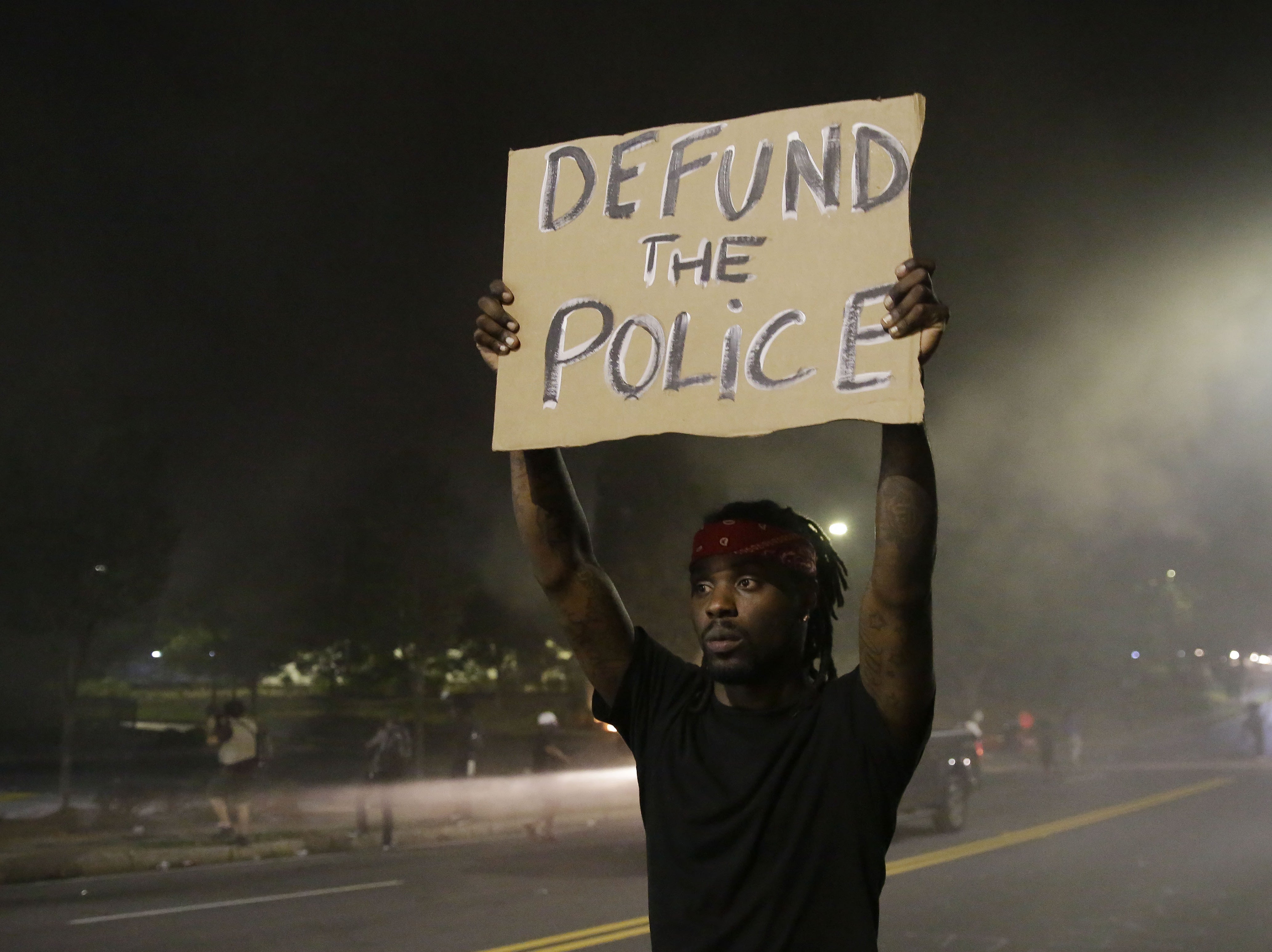 A man holds up a sign during a protest Saturday near the Atlanta Wendy's where Rayshard Brooks was killed.