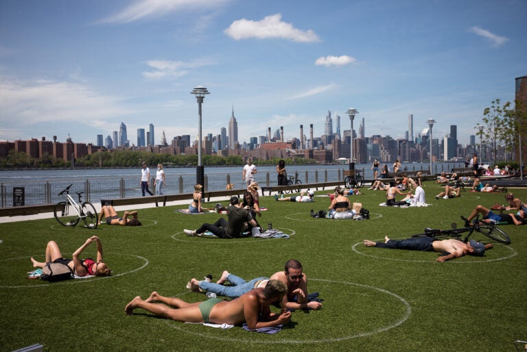 People rest inside social distancing markers at Domino Park in the Brooklyn borough of New York in late May. Stay-at-home orders in New York helped to lower the state's 