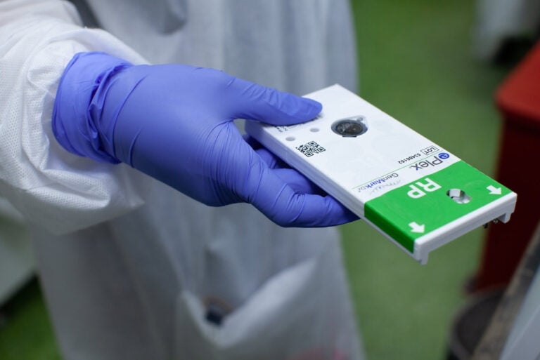 A nurse prepares to process a COVID-19 testing kit for results. (Eman Mohammed/NPR)