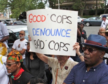 Protesters rallied outside the Philly police headquarters to demand the firing of officers identified in the Facebook database. (Emma Lee/WHYY)