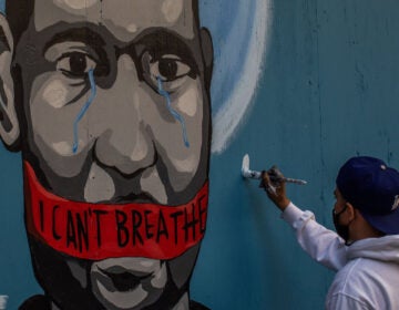 The artist Celos paints a mural in downtown Los Angeles on May 30, 2020 in protest against the killing of George Floyd by police in Minneapolis. (Apu Gomes/AFP via Getty Images)