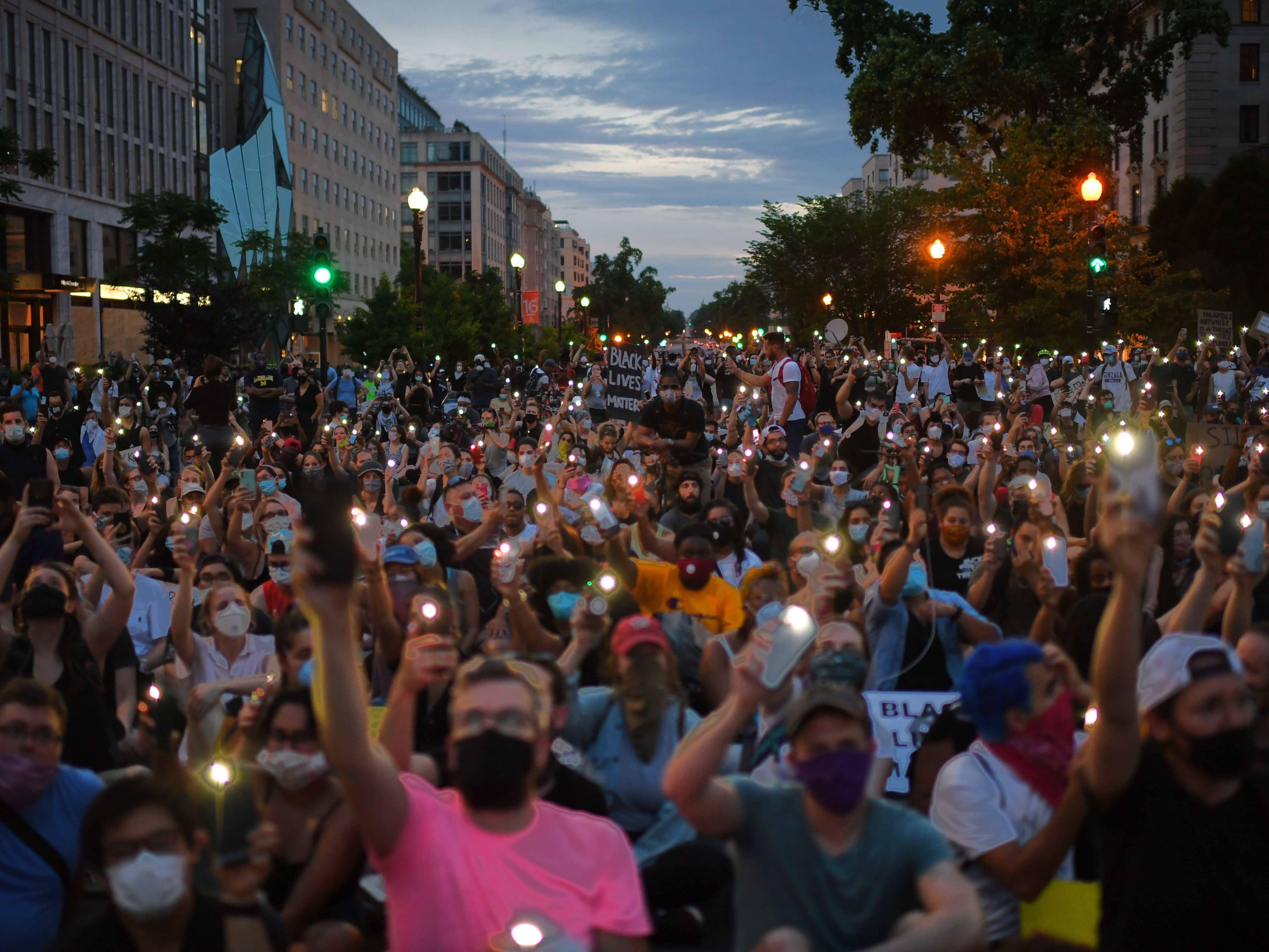 Protesters hold up their phones during a demonstration near the White House over the death of George Floyd.