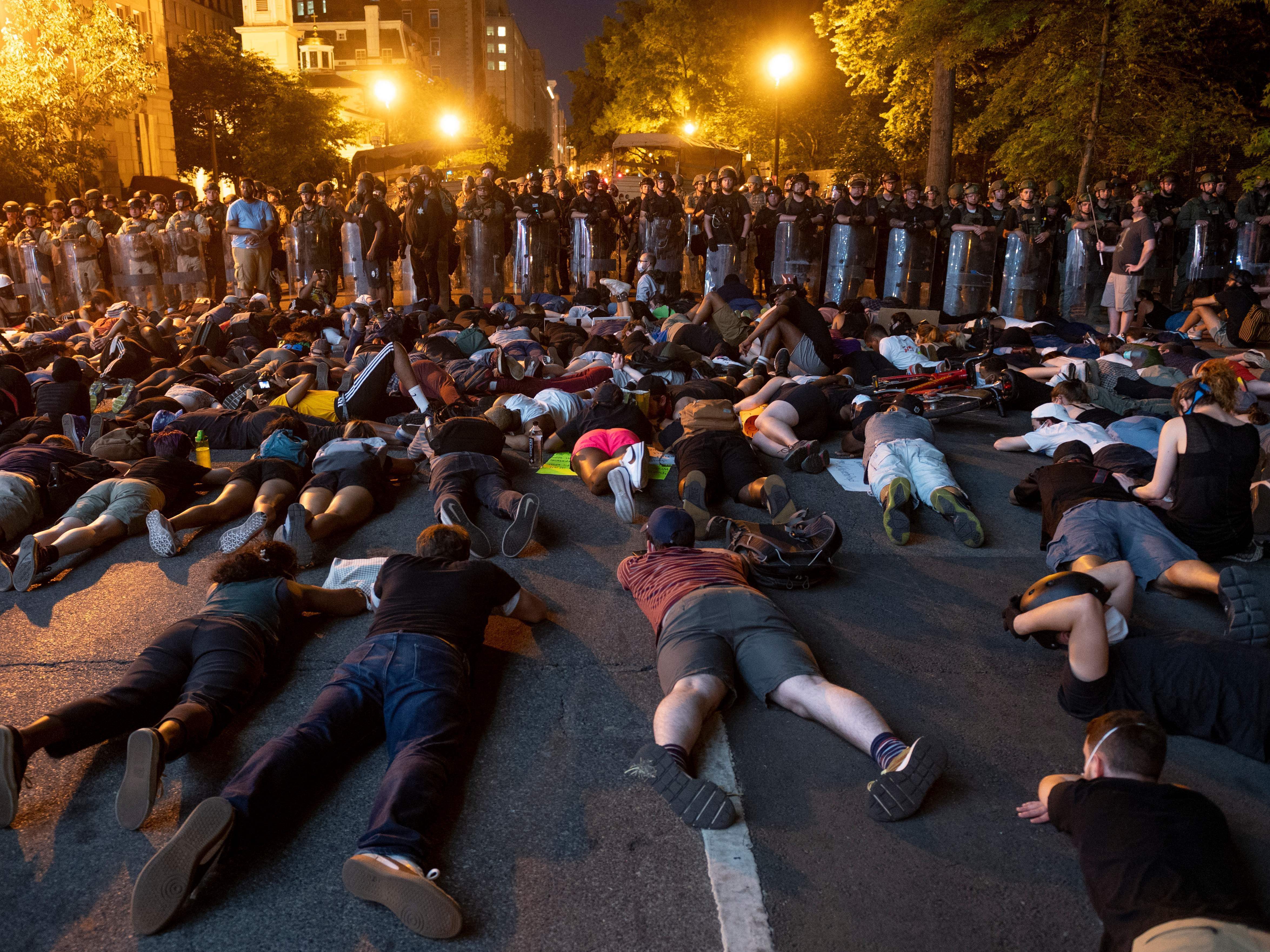 Demonstrators lay on the ground facing a police line in front of the White House during protests in Washington, D.C.