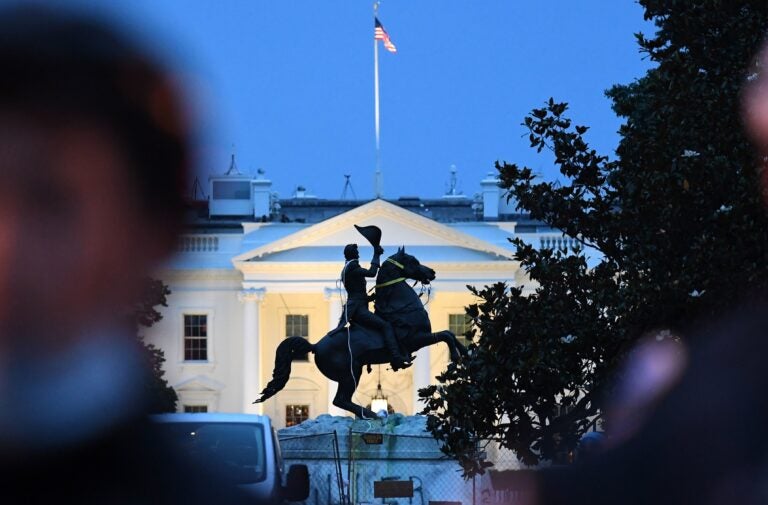 Police officers stand guard with the statue of former President Andrew Jackson after protesters tried to topple it Monday in Lafayette Square in Washington, D.C.