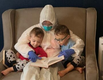 Dr. Lauren Jenkins reads to her twin sons, Pierce and Ashton, while wearing her 