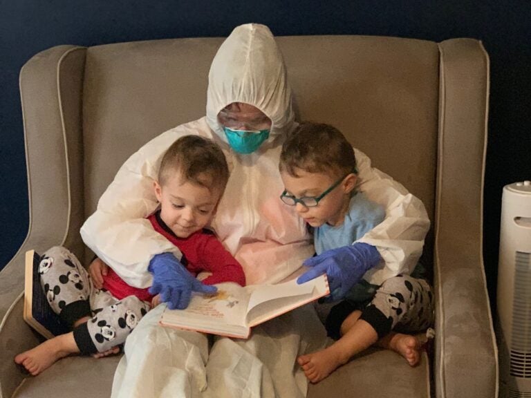 Dr. Lauren Jenkins reads to her twin sons, Pierce and Ashton, while wearing her 