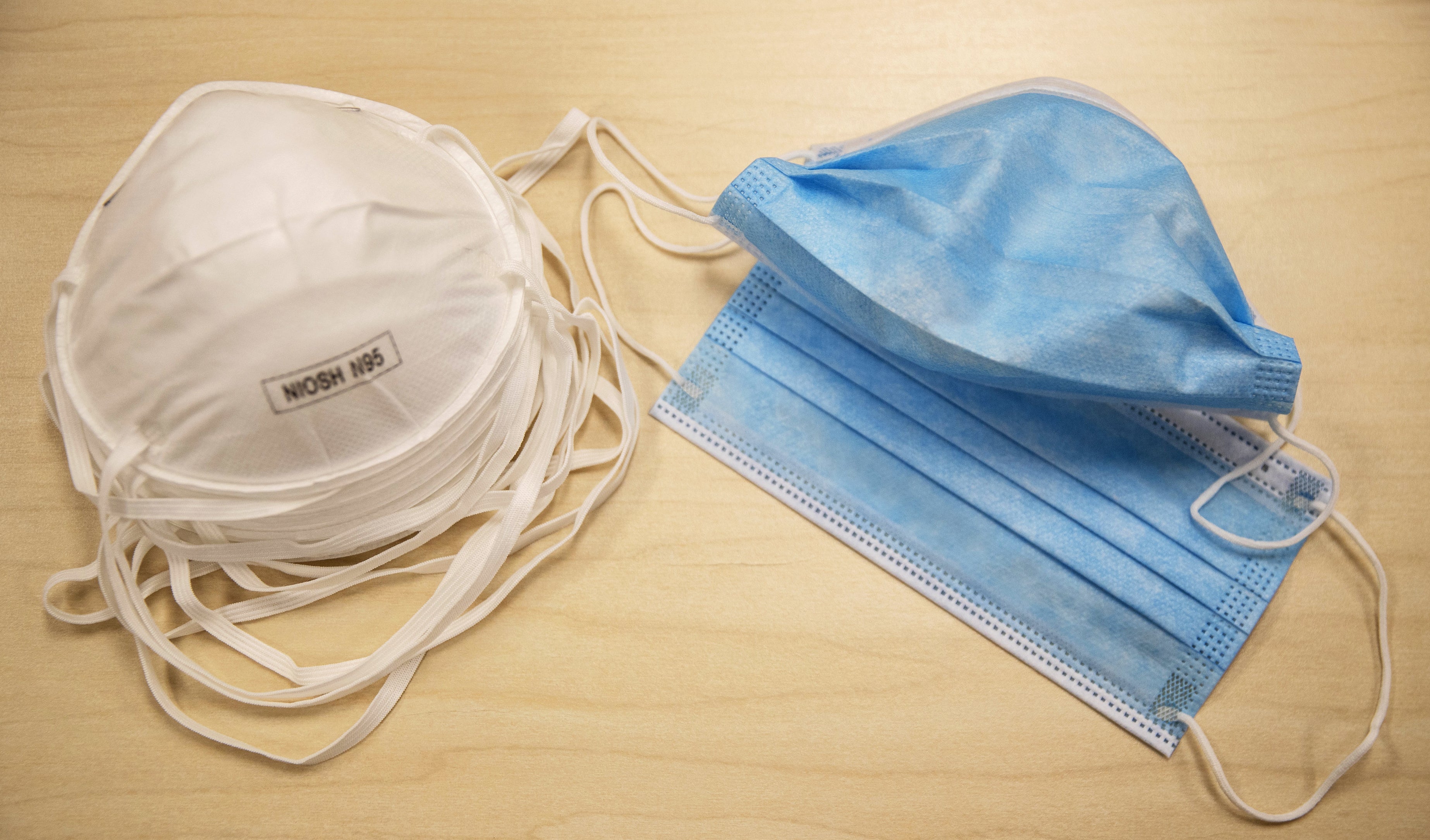 N95 particulate respirator masks left) block 95% of small airborne particulates in the air, however they are still in short supply and should be reserved for medical workers. Surgical face masks (right) are most effective at protecting others from the wearer's droplets.