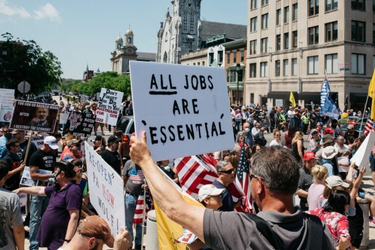 Protesters hold signs during a May 15, 2020, rally outside the state capitol in Harrisburg, Pa. About 1,000 people showed up to protest Gov. Wolf's coronavirus shutdown order. (Katie Landis/PA Post)