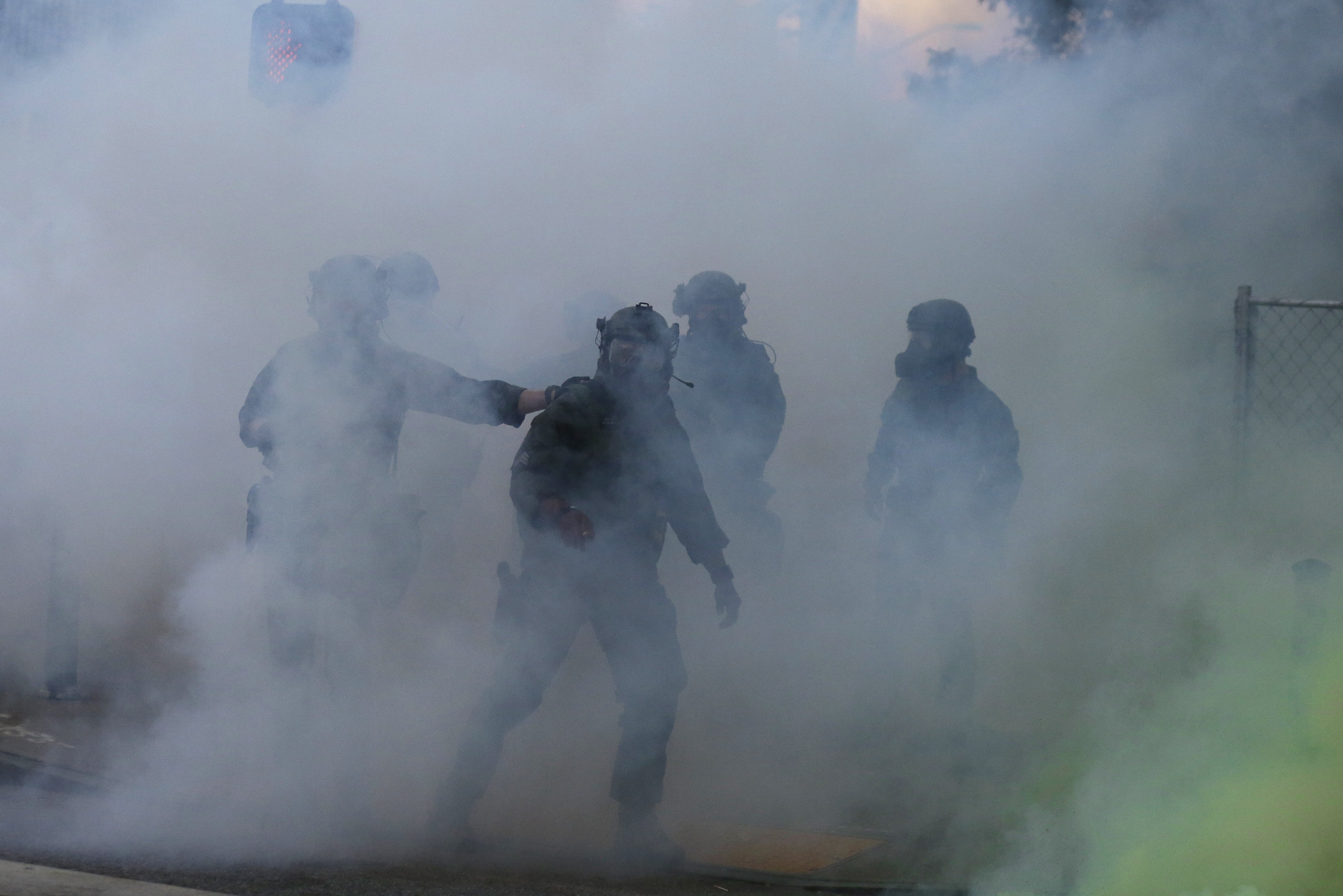 Police move through tear gas as demonstrators march on Sunday in Atlanta.