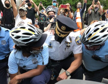 Officer Quishanna Lee, who has served on the force for three years, knelt with protesters Tuesday, and cried. (Layla A. Jones/Billy Penn)